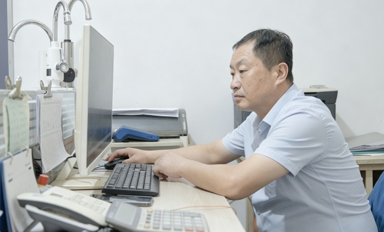 20260929113635930 杨军朝在办公室查看市场资料